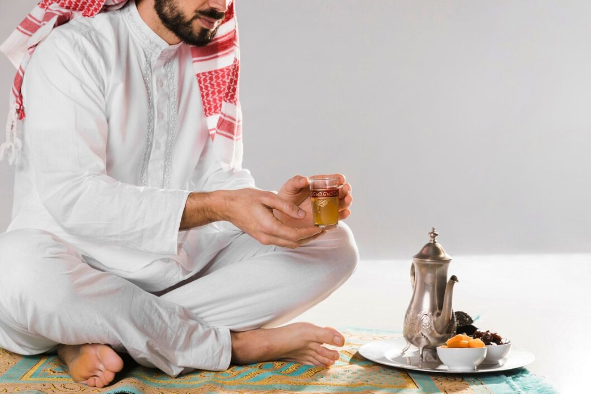 Pria dengan pakaian muslim hendak minum teh